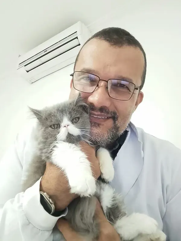 Dr. Ozório segurando um gato cinza