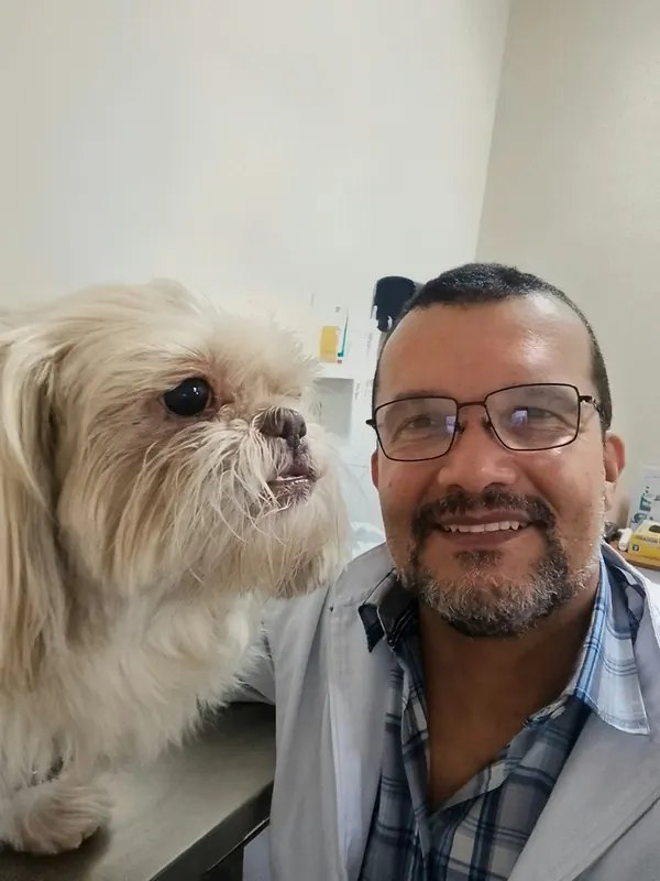 Dr. Ozório ao lado de um shih tzu